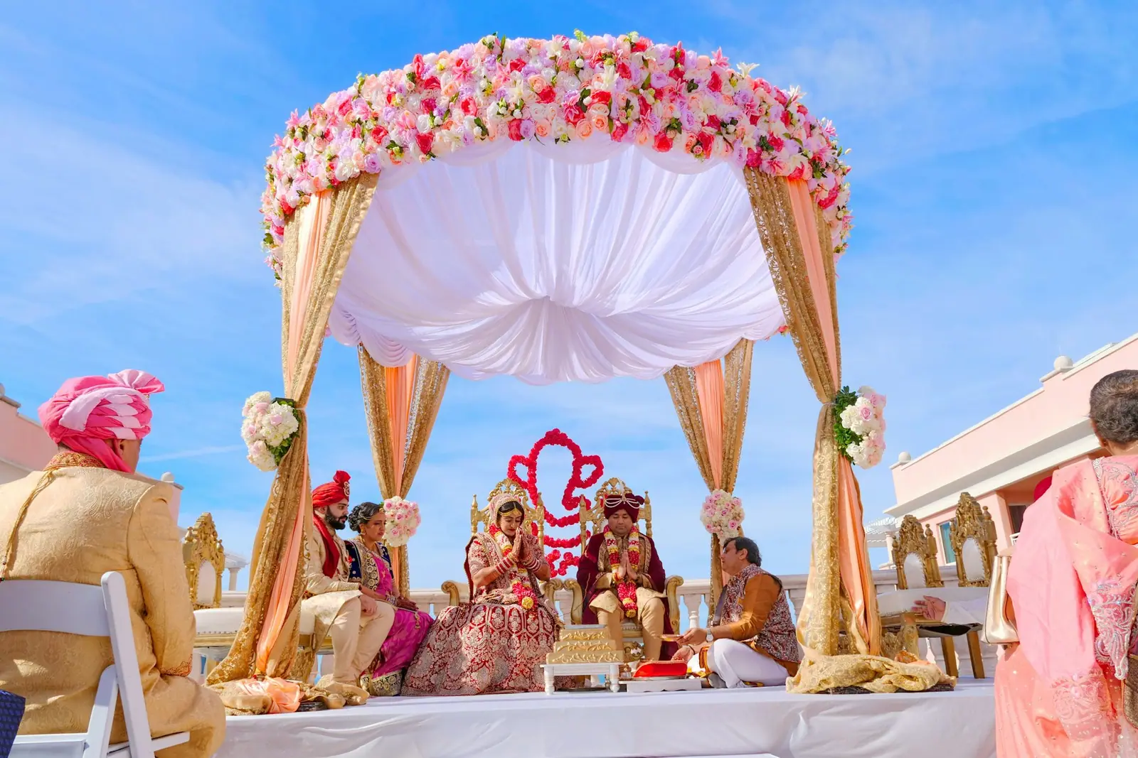 Wedding couple beneath a floral mandap