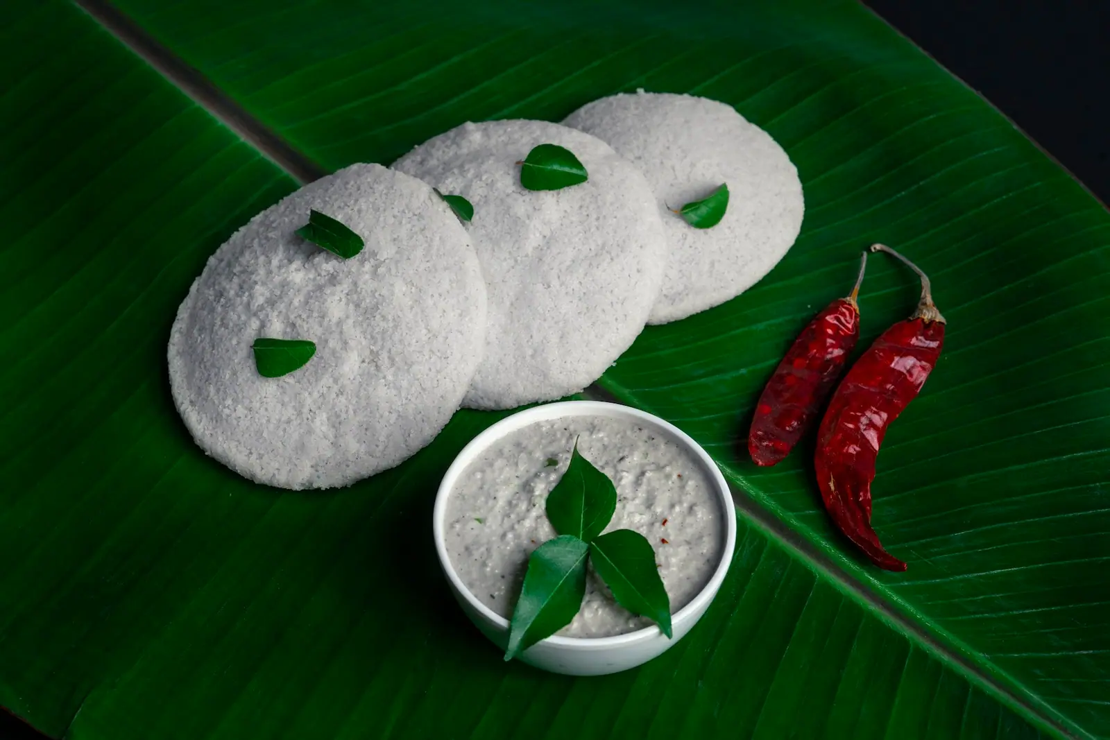 Soft idlis on a banana leaf with chutney